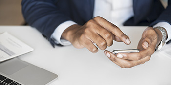 Businessman sending email on a cell phone