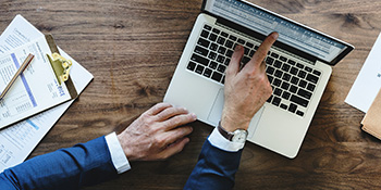 Man pointing at laptop computer screen